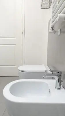 a white bathroom with a sink and a toilet at Aria Charme in Rome