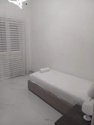 a white bedroom with a bed and a window at 612 Flats in Rome