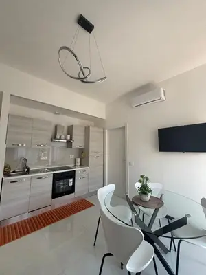 a kitchen with a glass table and white chairs at 612 Flats in Rome
