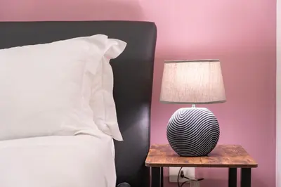 a lamp on a table next to a bed at Piazza Cavour Apartment 90 in Rome