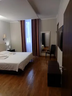 a hotel room with a bed and a chair at StefanoHouse Barberini 2 appartamenti in Rome