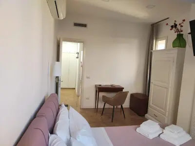 a room with a bed and a table and a desk at Piccola Domus in Rome
