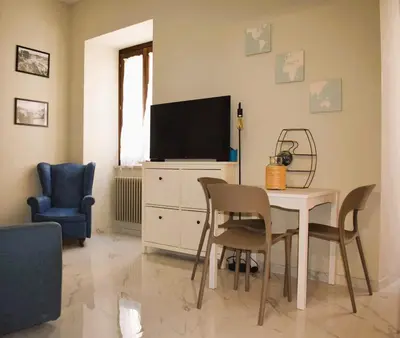 a living room with a tv and a table and chairs at A casa di Cicca in Rome