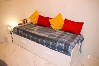 a bed with red and yellow pillows on it at A casa di Cicca in Rome