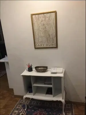 a small white table with a picture on a wall at Diana's Loft in Rome