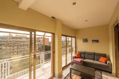 a living room with a couch and large windows at Spacious and Bright 3BR Family Apartment in Rome
