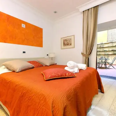 a bedroom with a large orange bed with towels on it at Il patio al Colosseo in Rome