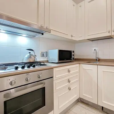 a kitchen with a stove top oven next to a microwave at Il patio al Colosseo in Rome