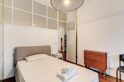 a small bedroom with a bed and a mirror at Etiopia Apartment in Rome