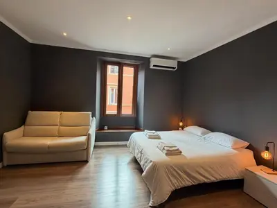 a bedroom with a bed and a chair and a window at San Lorenzo Elegance Suites - just steps from the Colosseum in Rome