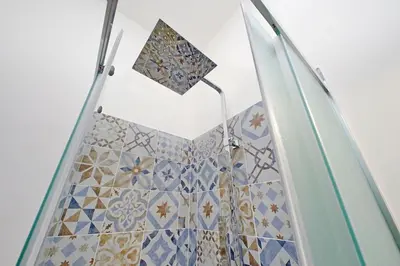 a bathroom with a shower with blue and white tiles at Monica's house in Rome