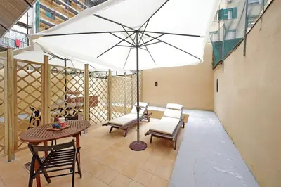 a patio with a table and chairs and an umbrella at Monica's house in Rome