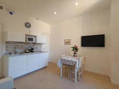 a kitchen with a table and a tv on the wall at La Casa di MiDa in Rome