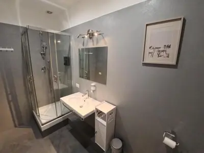 a bathroom with a shower and a sink and a mirror at Benny's House Rome in Rome