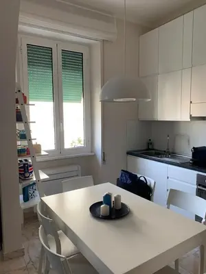 a kitchen with a table and chairs and a kitchen with white cabinets at Miss Giulia Prime location flat in Rome in Rome
