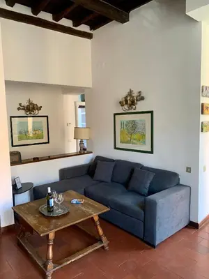 a living room with a blue couch and a table at Domus Antonella a Trastevere in Rome
