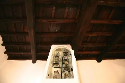 a room with wooden ceilings and a shelf with figurines at Domus Antonella a Trastevere in Rome