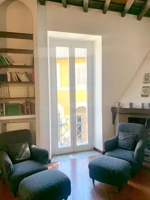 a living room with two chairs and a sliding glass door at Domus Antonella a Trastevere in Rome