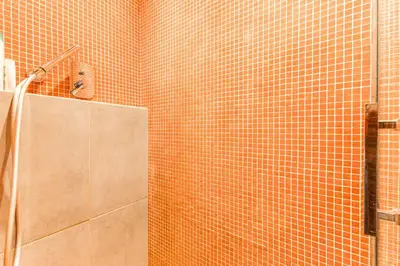 a bathroom with orange tiled walls and a shower at Loves Home in Rome