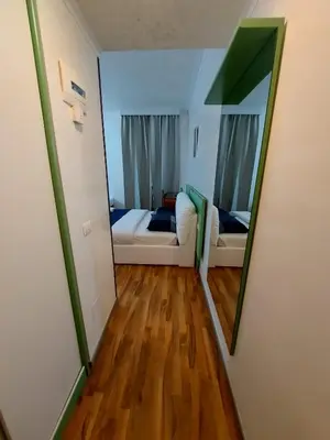 a mirror in a room with a couch and a bed at Hotel Positano 2 MIMOSA in Rome