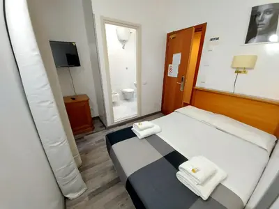 a bedroom with a bed with two towels on it at Hotel Positano 2 MIMOSA in Rome