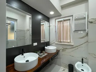 a bathroom with two sinks and two mirrors at Il giardinetto di Ponte Milvio in Rome