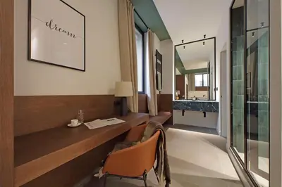 a hotel room with a desk and a sink at Crispi Loft - My Extra Home in Rome