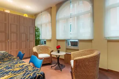 a bedroom with wicker chairs and a table and a bed at GuestHost - Pretty Apartment near Musei Vaticani in Rome