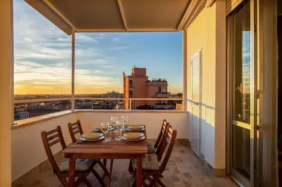 a table on a balcony with a view of the city at Penthouse Lux with Panoramic View in Rome