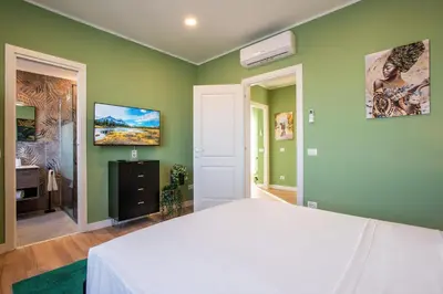 a bedroom with a white bed and green walls at Penthouse Lux with Panoramic View in Rome