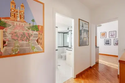 a hallway with a bathroom with a painting on the wall at Luxury Penthouse with Terrace by Spanish Steps in Rome