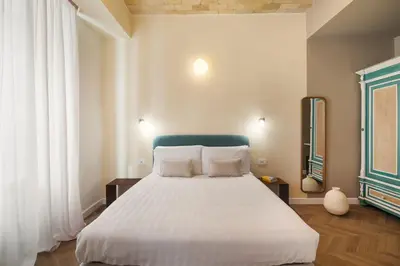 a bedroom with a large bed with white sheets at Elegantia Luxury Rooms Trastevere in Rome