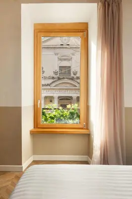 a bedroom with a window with a view of a building at Elegantia Luxury Rooms Trastevere in Rome