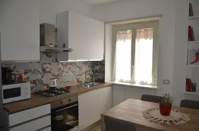a kitchen with white cabinets and a table with a microwave at 50 al Vaticano House in Rome