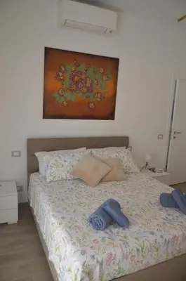a bed in a bedroom with a painting on the wall at 50 al Vaticano House in Rome