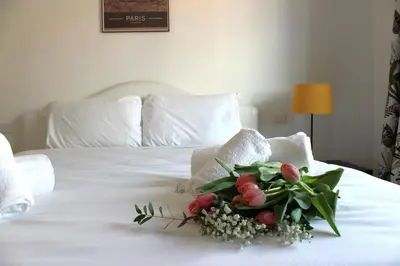 a bouquet of flowers sitting on top of a bed at Roma Luxury Apartment in Rome