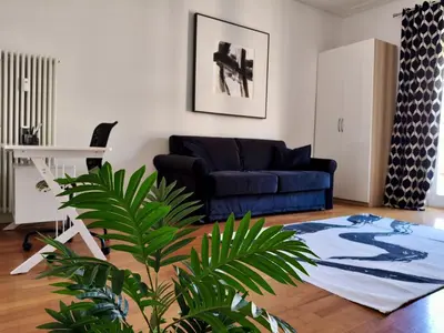 a living room with a blue couch and a plant at Roma Luxury Apartment in Rome