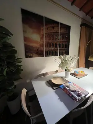 a white table with chairs and a picture of the coliseum at S Angelo Apartment in Rome