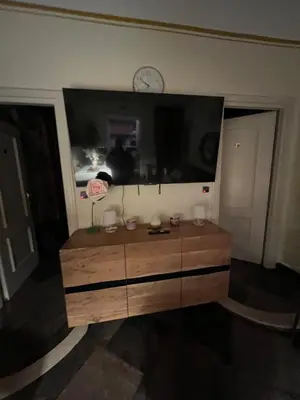 a living room with a large tv and a wooden dresser at S Angelo Apartment in Rome