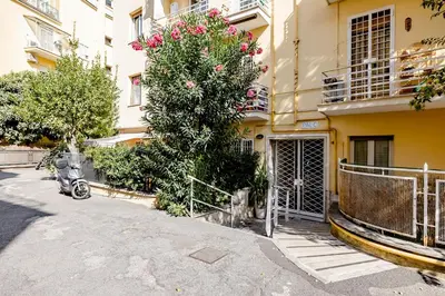 a building with a tree with pink flowers on it at Appartamento Moderno-H2OME nuovo in Rome