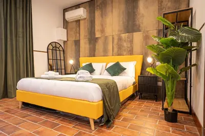 a bedroom with a yellow bed and a plant at Trastevere 1 in Rome