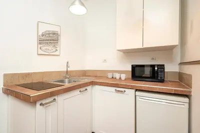 a white kitchen with a sink and a microwave at Trastevere 1 in Rome