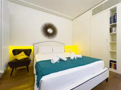 a bedroom with a large white bed and a chair at Gold Suite 5 minuti dal Colosseo in Rome