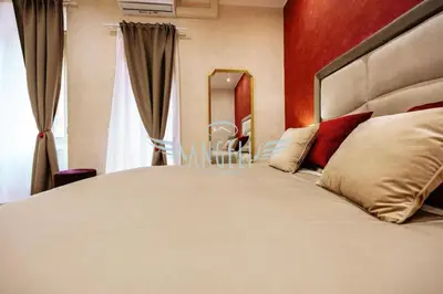 a bedroom with a large bed and a mirror at BlueHouse Roma, ampia casa per gruppi e famiglie in Rome