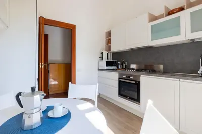 a kitchen with white cabinets and a table with a blender at Roman Retreat Near the Appian Way & Catacombs in Rome