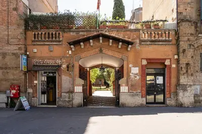 an entrance to a building with an arch with a balcony at Courtyard Doria Comfort & Style at Vatican Museums in Rome