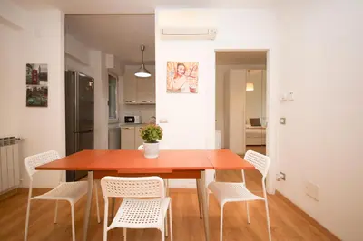 a dining room with a wooden table and white chairs at Maison Tiburtina by Ghor in Rome