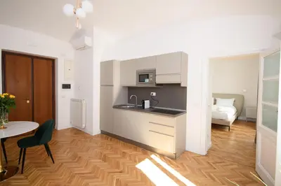 a kitchen and living room with a table and a bed at Boncompagni Serenity Suites in Rome