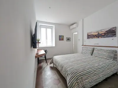 a bedroom with a bed and a desk and a window at Ostiense 353 Apartment by RS in Rome