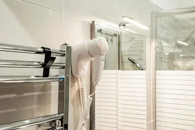 a white hair dryer is hanging in a bathroom at Vaticano-Cornelia Luxury Home in Rome